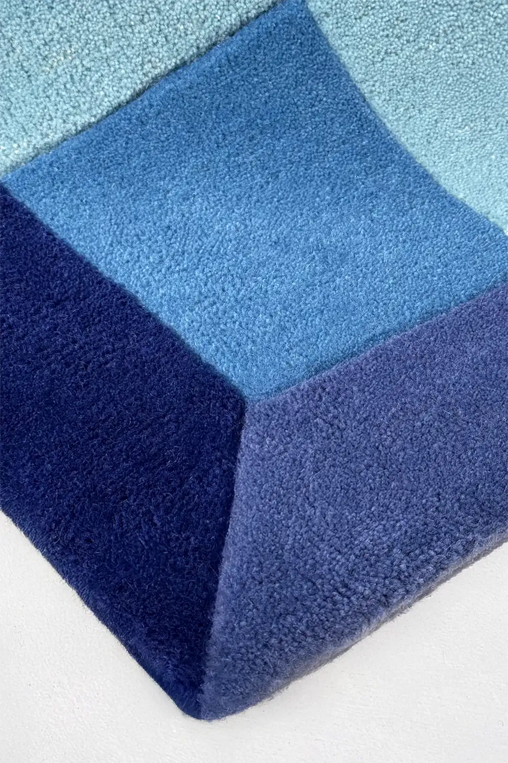 Blue geometric patterned rug on a white background