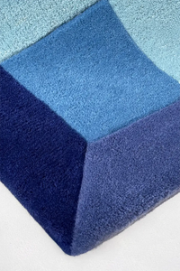 Blue geometric patterned rug on a white background