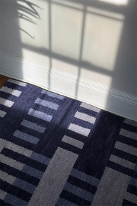 Patterned rug with geometric design on a wood floor in a sunny living room lifestyle