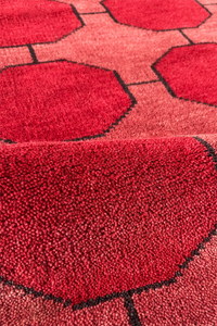 Close-up of a red textured rug with geometric pattern