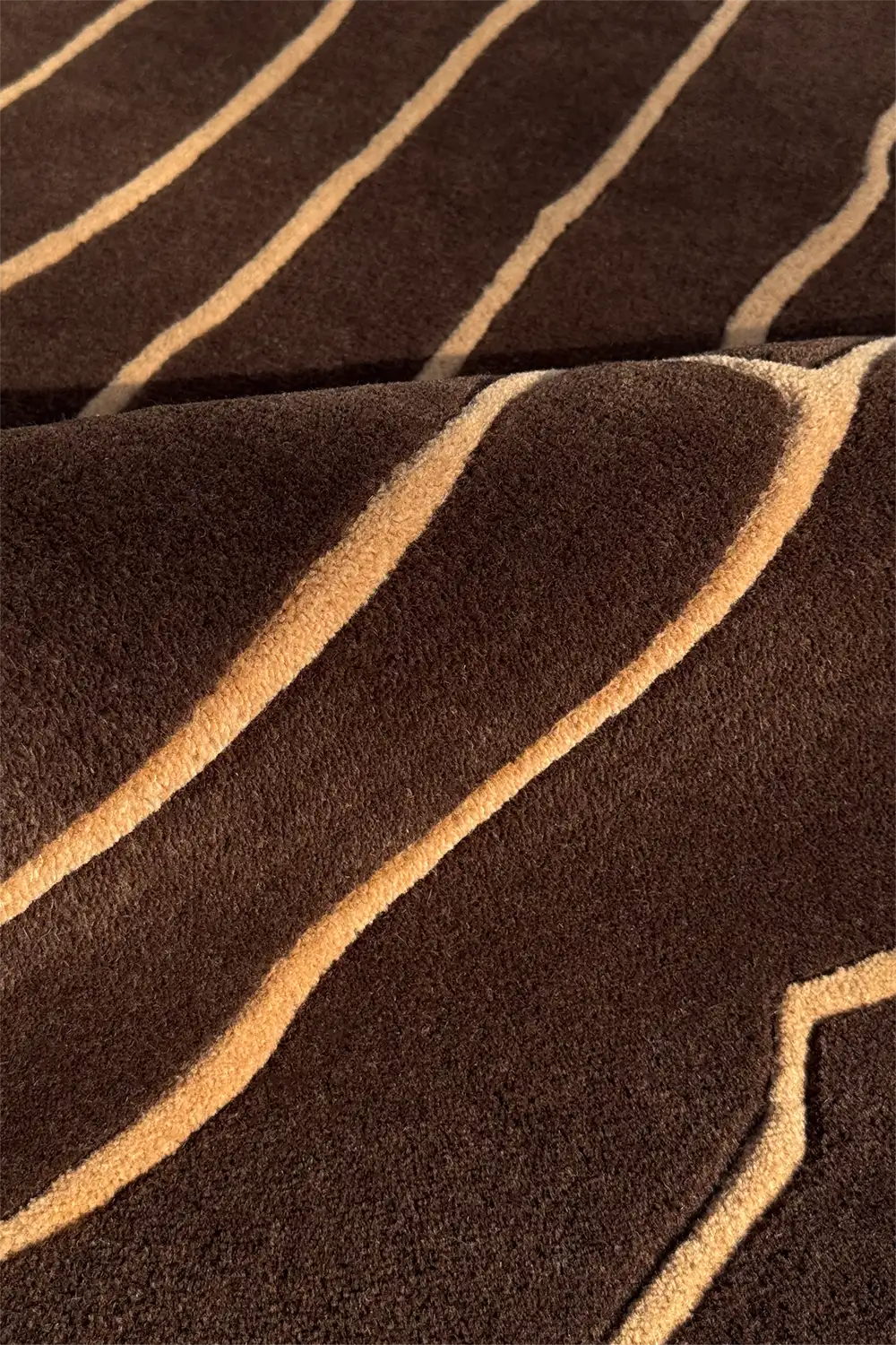 dark brown textured wool rug with gold lines