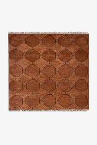 Brown square rug with a mid-century geometric pattern on a white background