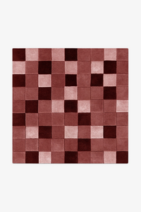 square checkered rug with burgundy and pink squares on a white background