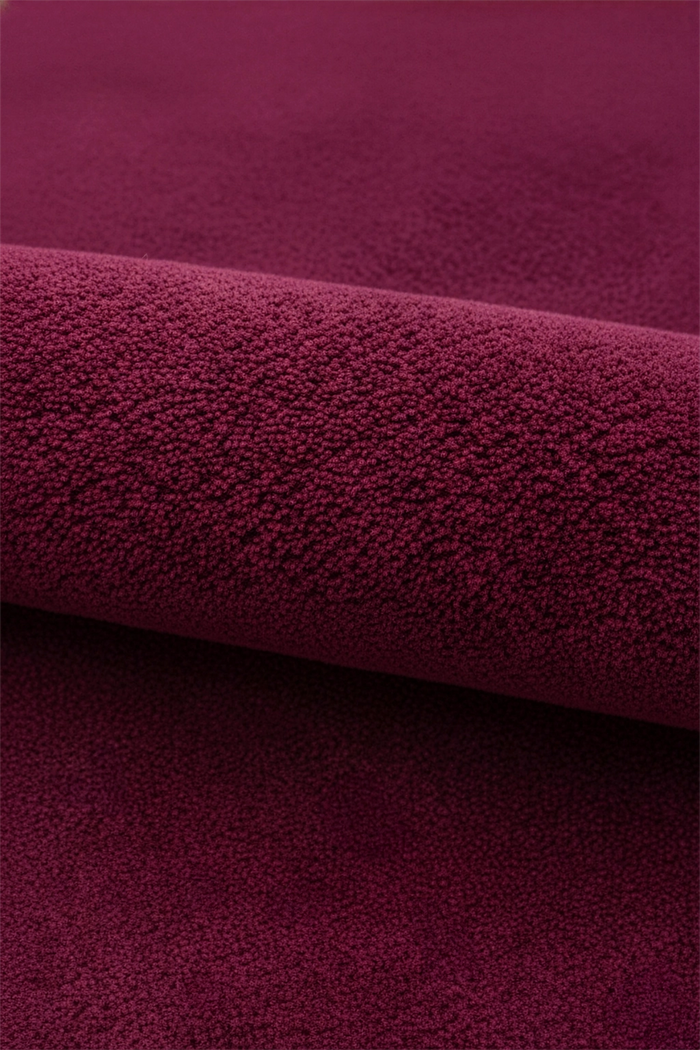 Close-up of burgundy purple pink wool rug texture
