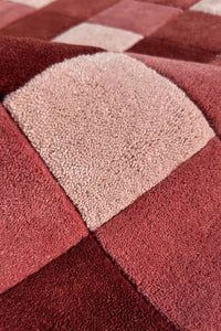 Close-up of a textured burgundy red and beige checkered rug