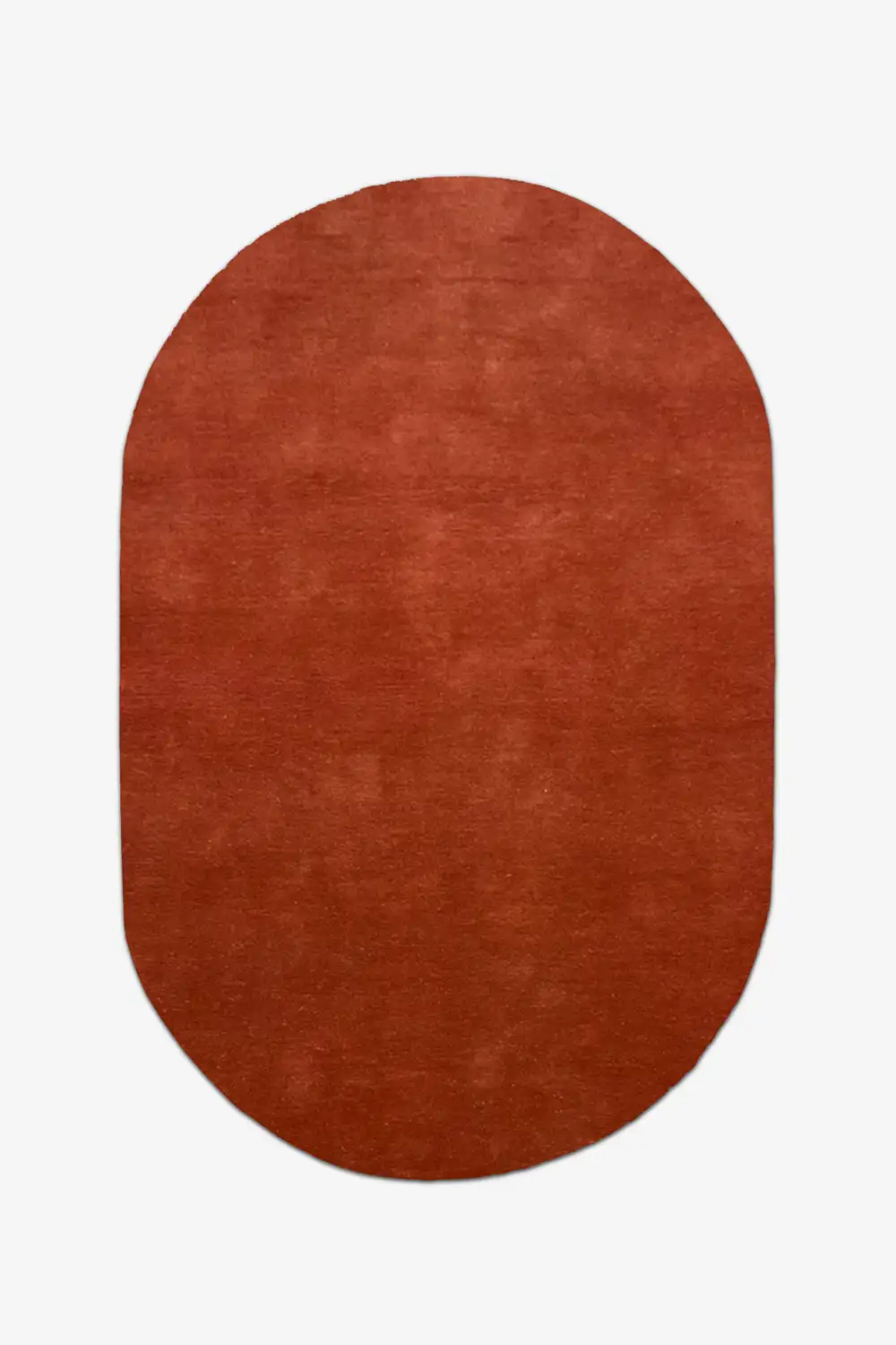 Oval-shaped burnt orange red rug on a white background