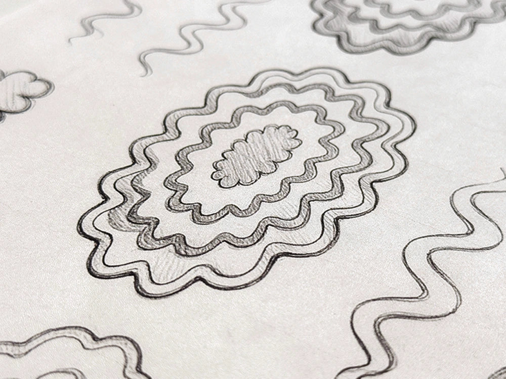 Pencil design sketches for the Burst hand-tufted wool rug, showing concentric scalloped rings rippling outward from a small bloom at the center of an oval.