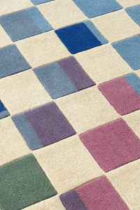 Checkered pattern rug with blue, purple, and green squares on a beige background