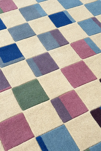 Patterned rug with square tiles in blue, purple, and green on a beige background