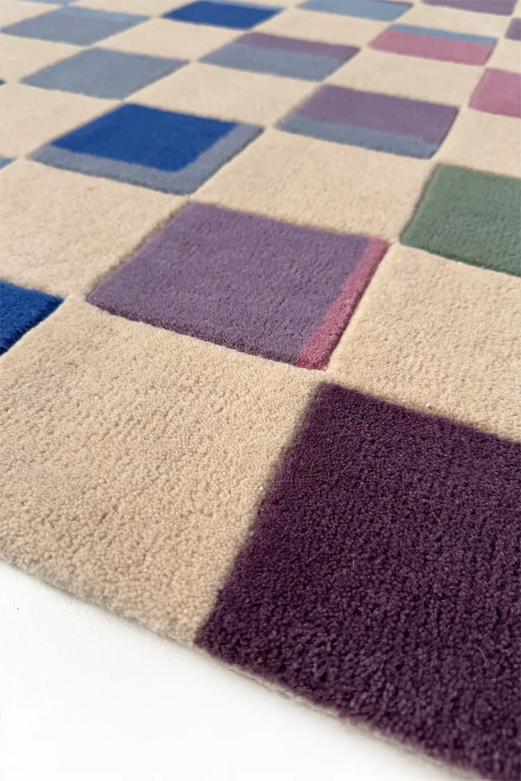 Checkered rug with squares in various colors on a white background