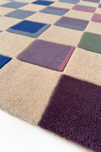 Checkered rug with squares in various colors on a white background