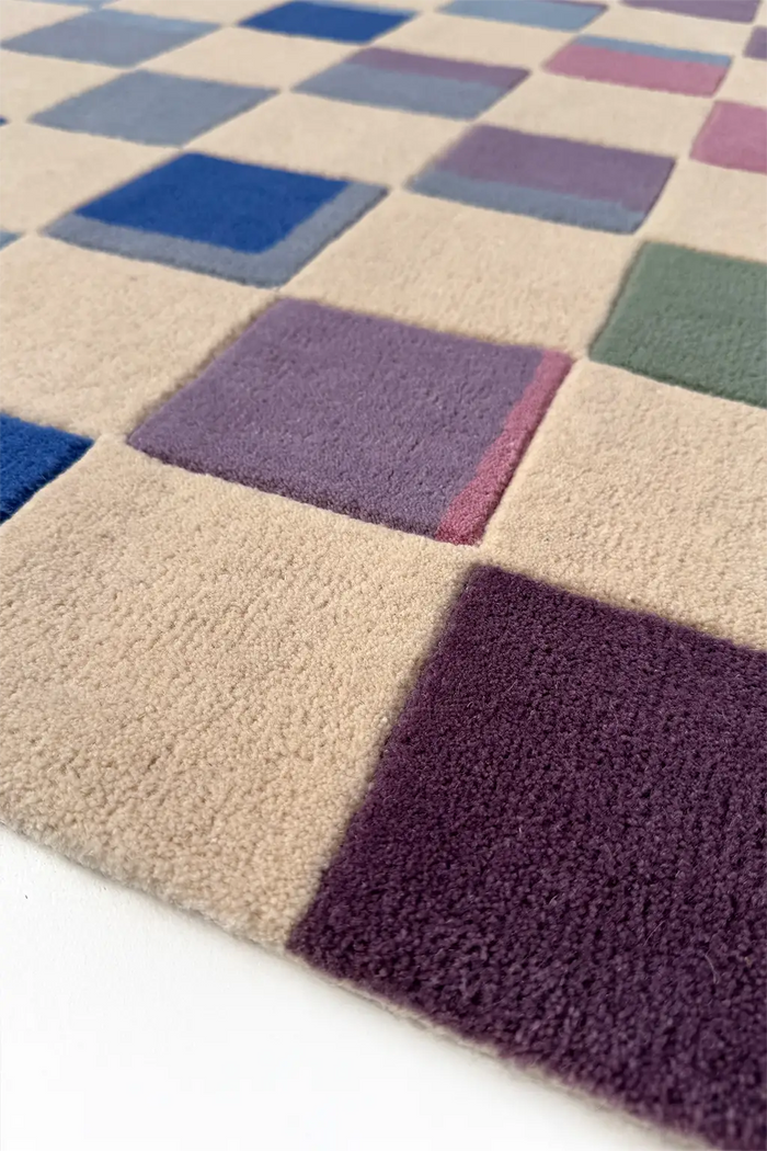 Checkered rug with squares in various colors on a white background