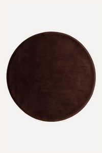 A round dark brown plush rug shown from a top-down view on a light off-white background.