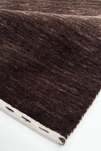 close-up texture of dark brown wool area rug with lines