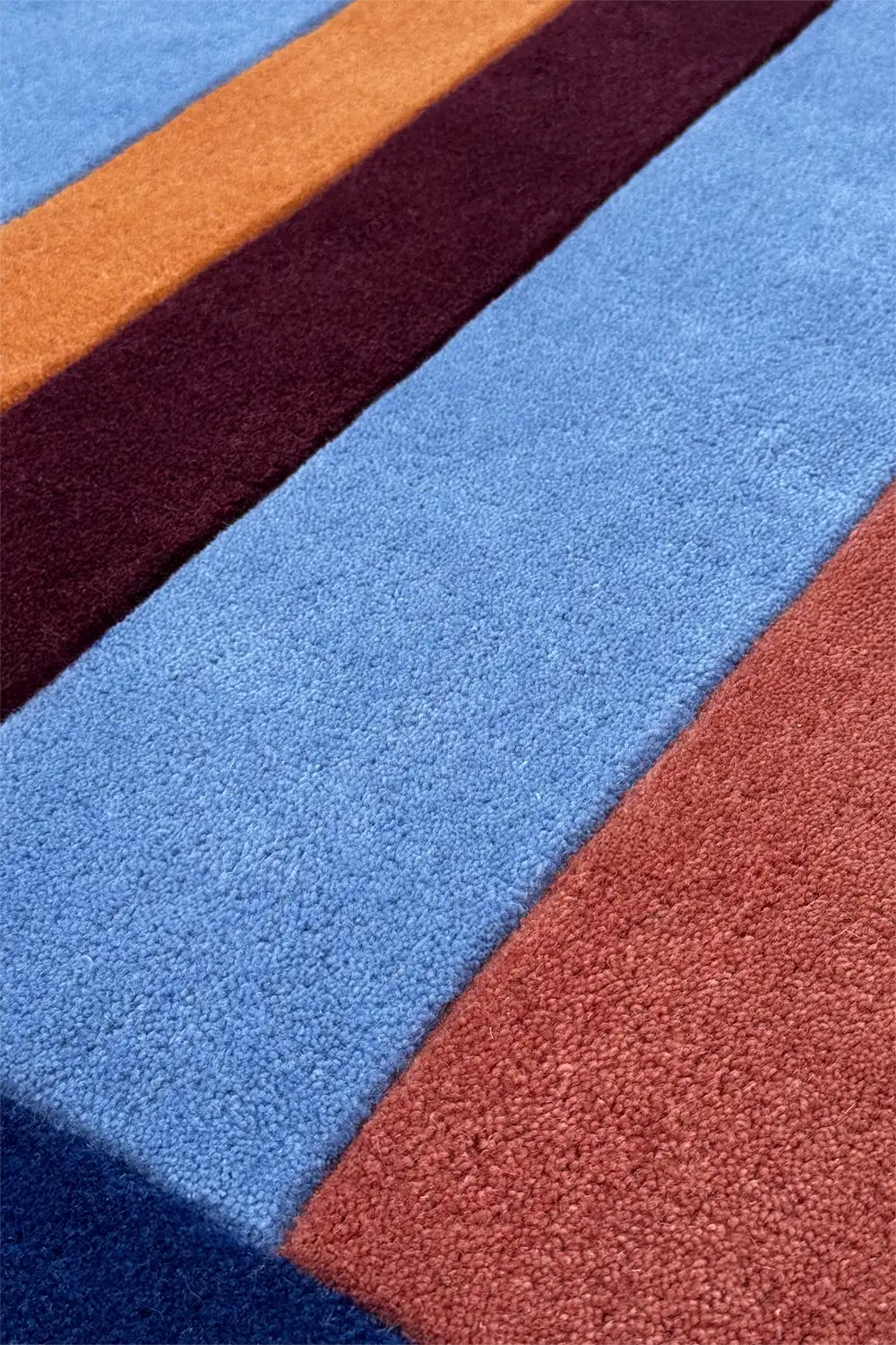 Close-up of a multicolored striped runner rug with blue, red, and burgundy stripes.