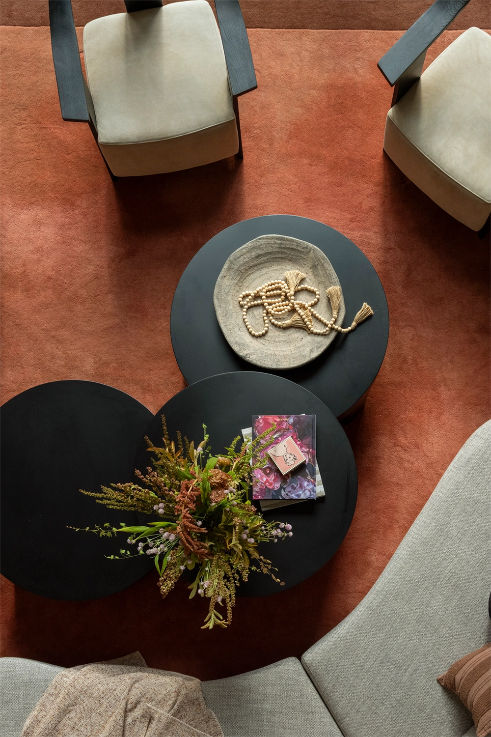 Top-down view of a large modern brown rug with a coffee table with decorative items in a living room setting.