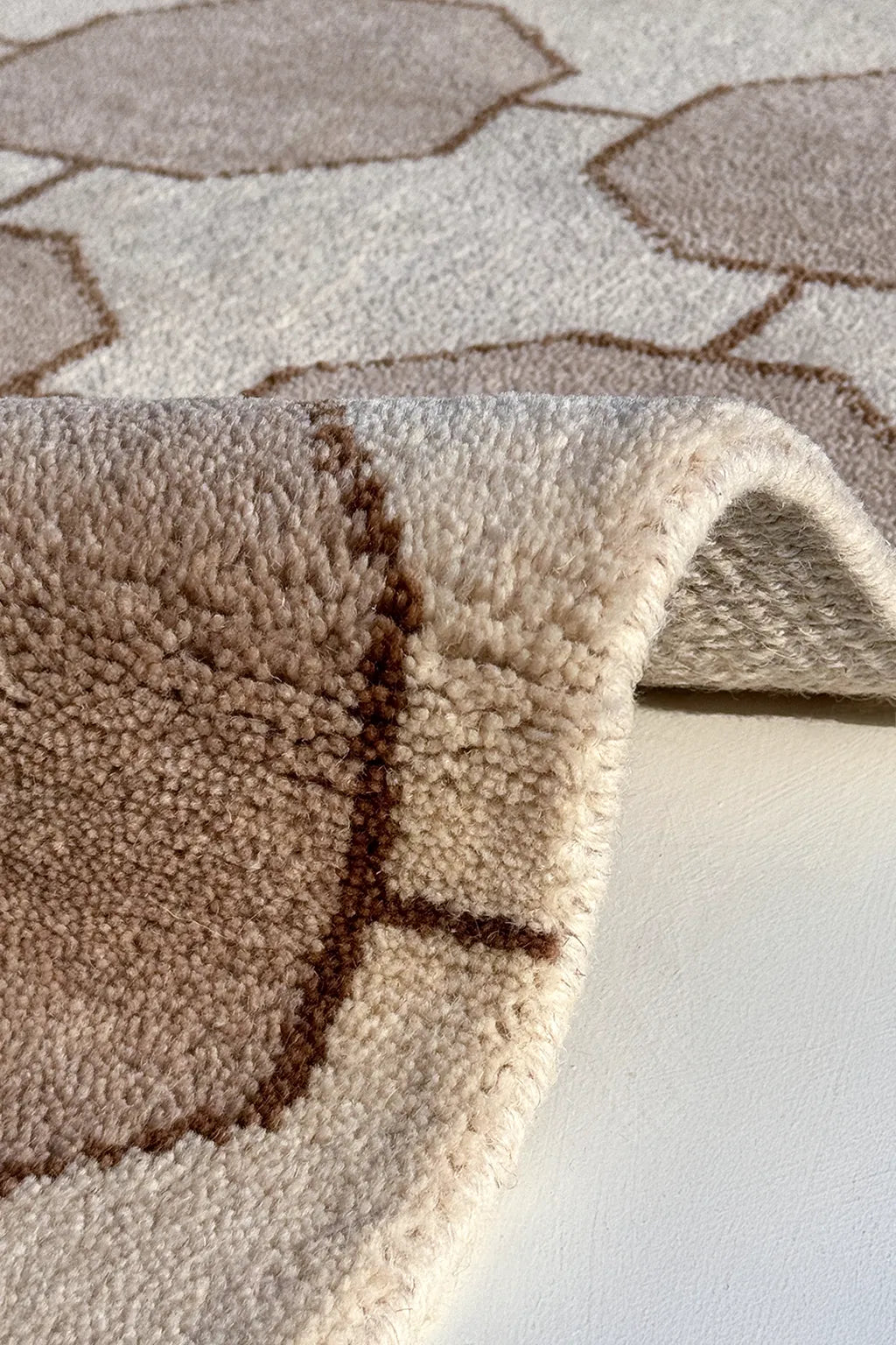 Close-up of a textured beige and brown  runner rug with geometric pattern on a white background