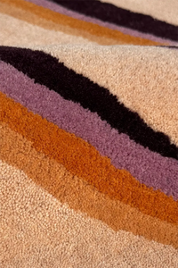 Close-up of a textured wool rug with multicolored stripes in retro style