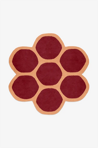 Round rug with a flower pattern in red and orange on a white background