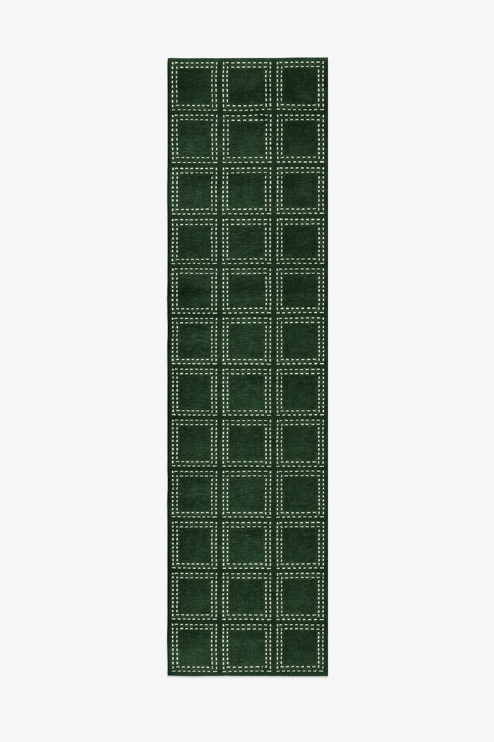 Green checkered runner rug with a white border on a white background