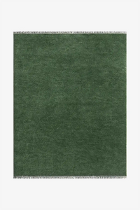 deep green knotted wool area rug with fringe on a white background