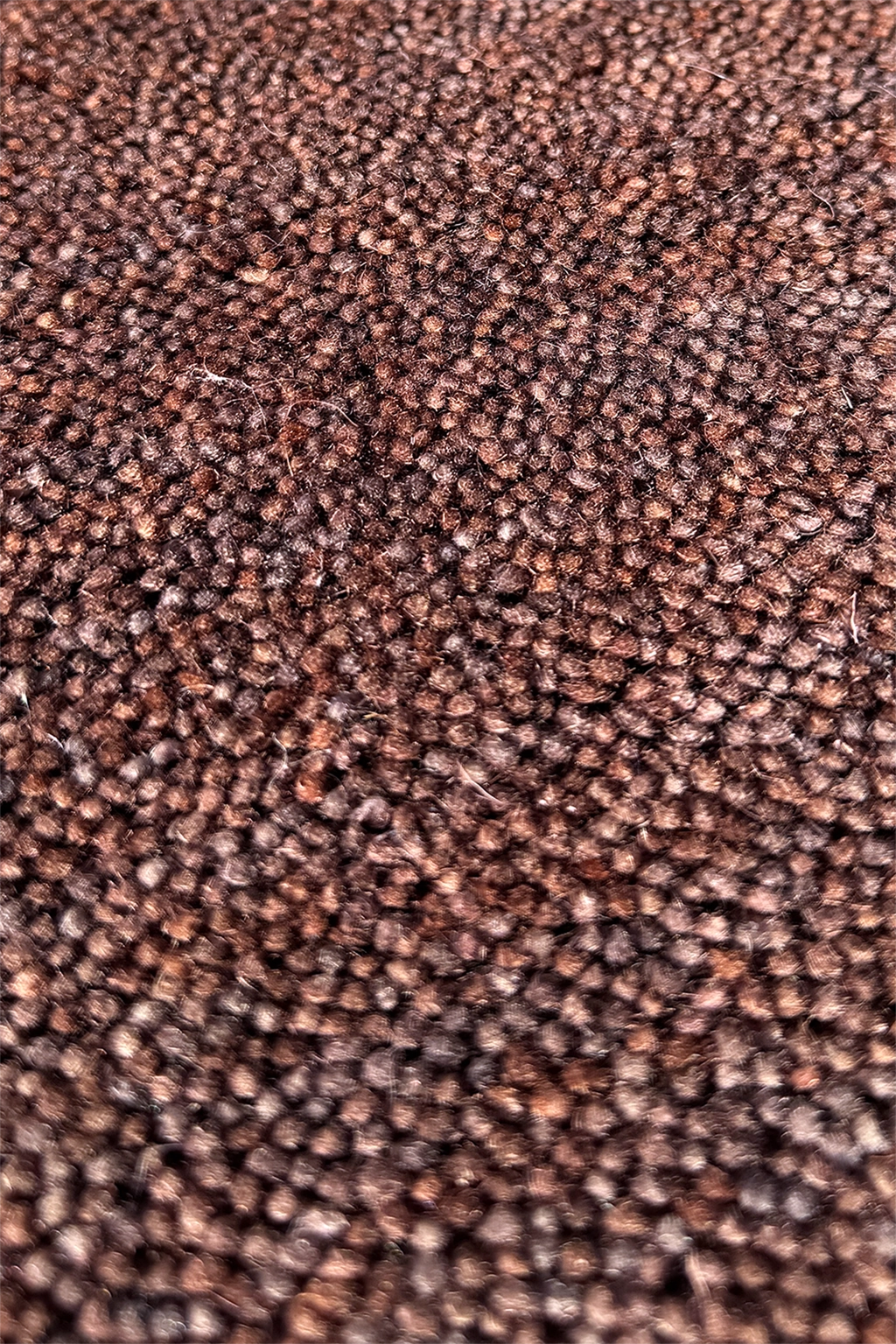 Close-up of dark brown textured wool carpet