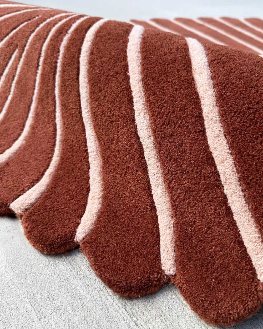 Wavy wool rug in rust and cream with tropical leaf shape, unique sculpted accent for vibrant rooms