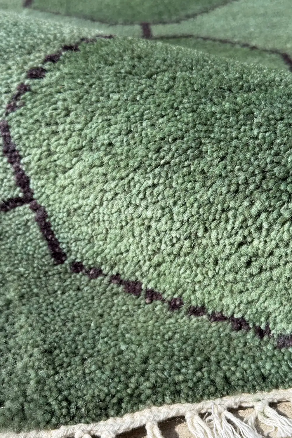 Custom geometric wool rug in deep green with hand-knotted octagon grid design