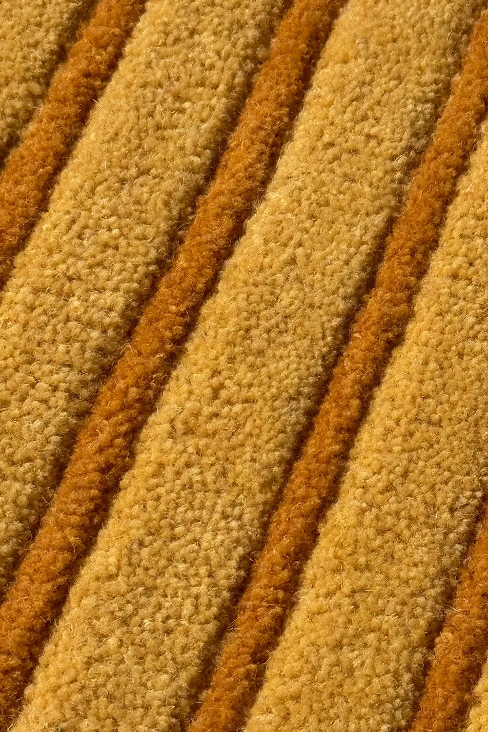 Close-up of textured beige and gold modern wool striped carpet