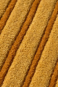 Close-up of textured beige and gold modern wool striped carpet