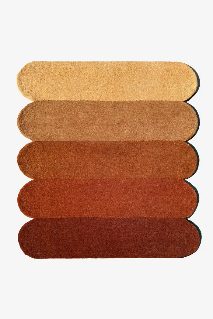 Modern 9x12 scalloped area rug in warm terracotta and burnt orange tones, perfect for mid-century or boho interiors