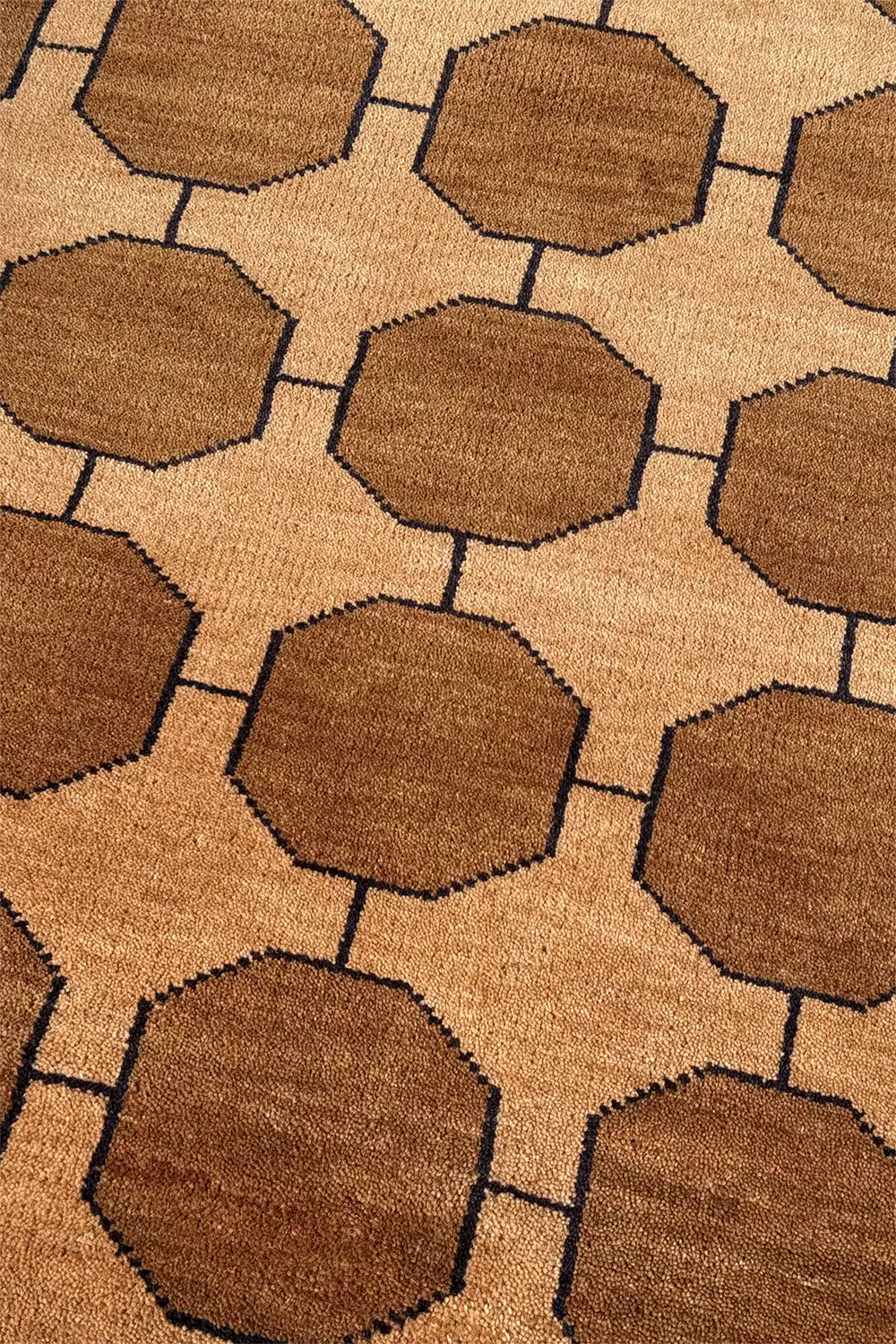 Patterned rug with honey gold brown octagonal shapes on a warm beige background