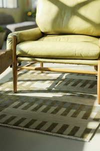 green square rug in a living room with striped pattern