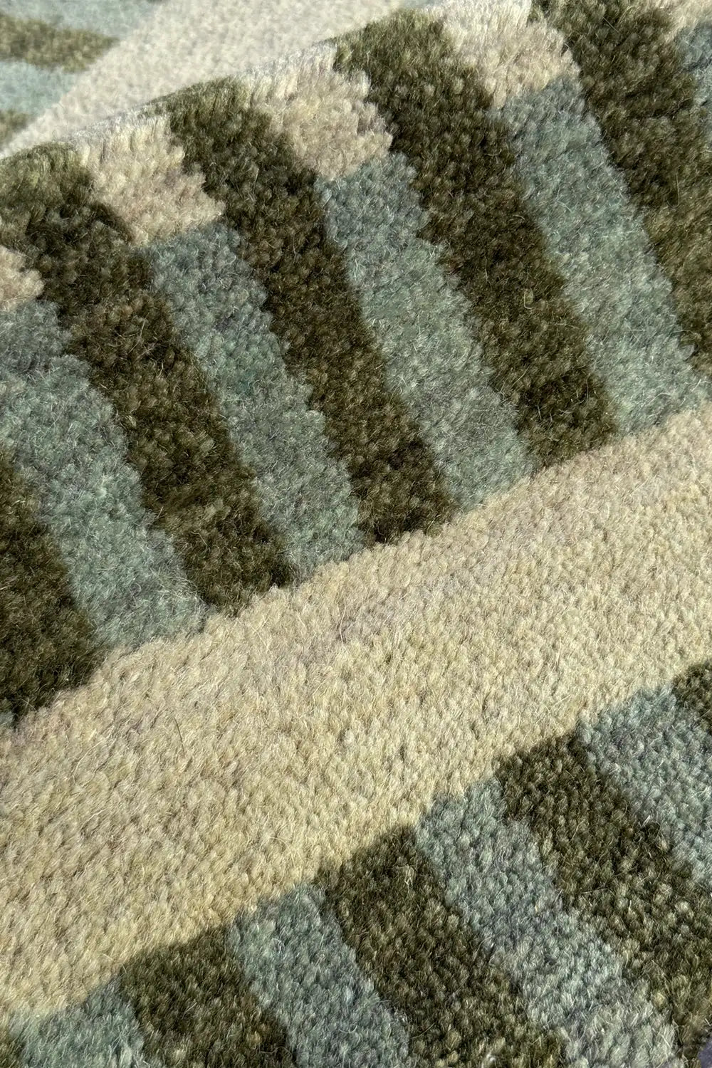 Close-up of a textured green rug with geometric pattern