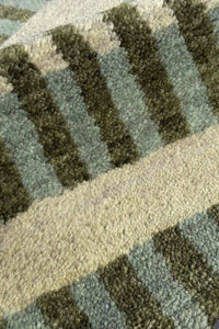 Close-up of a textured green rug with geometric pattern