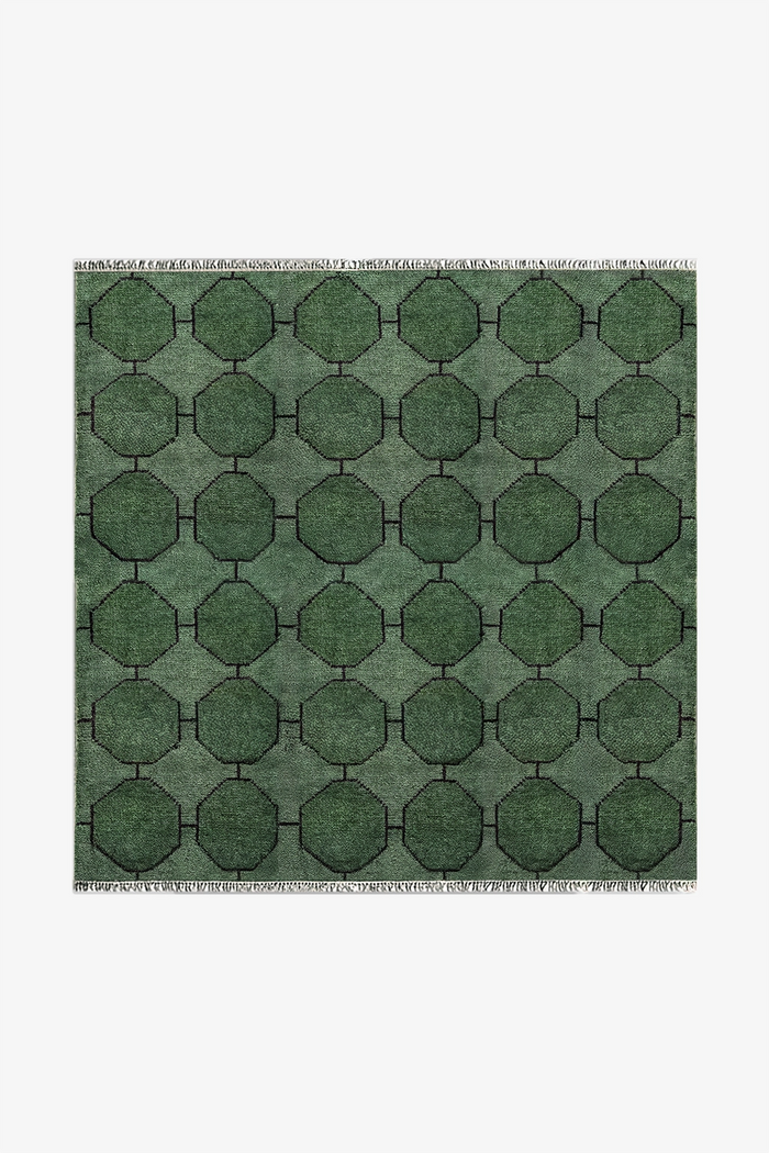 Green geometric patterned square rug on a white background