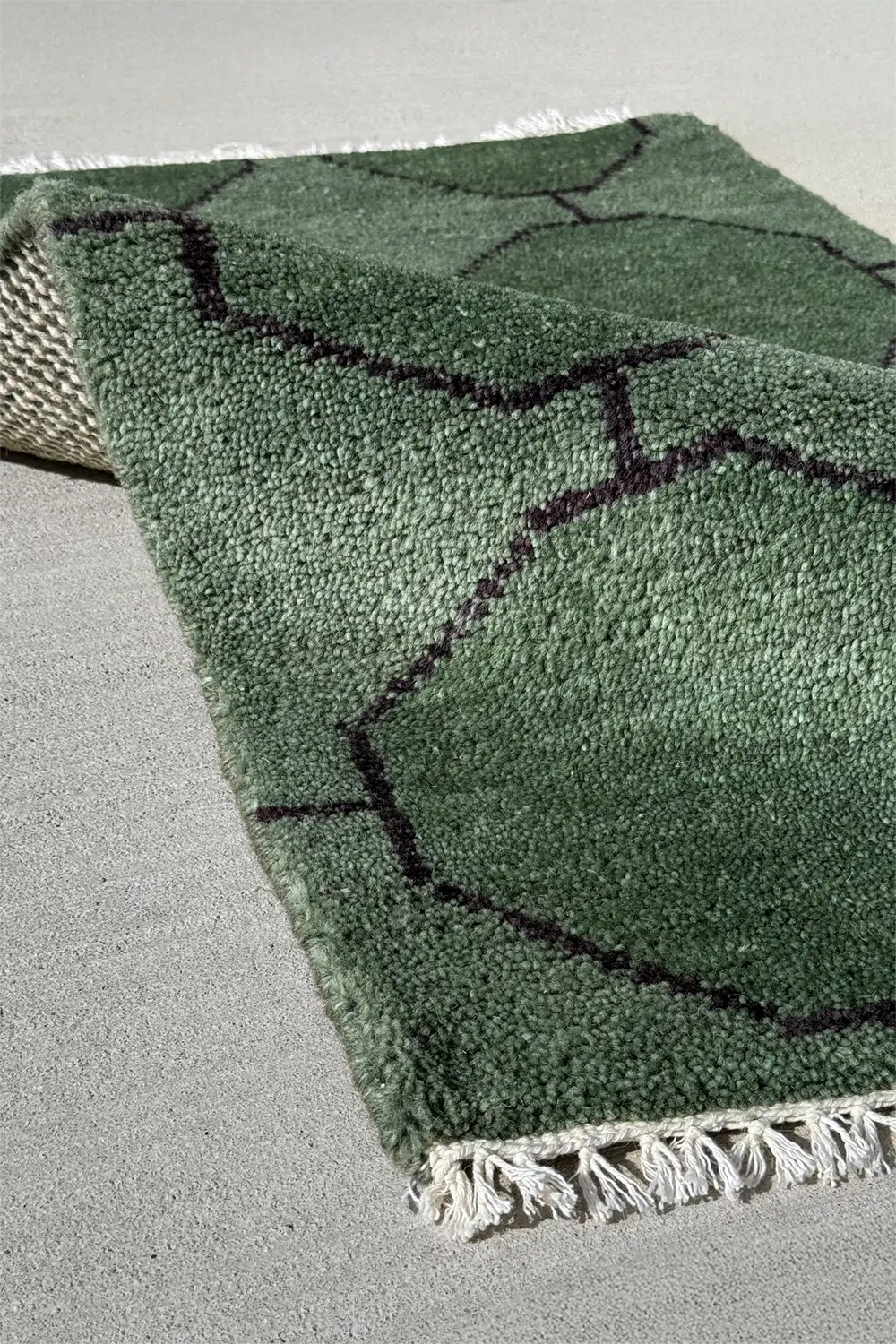 Green octagon wool rug with knotted construction and sculptural patterning