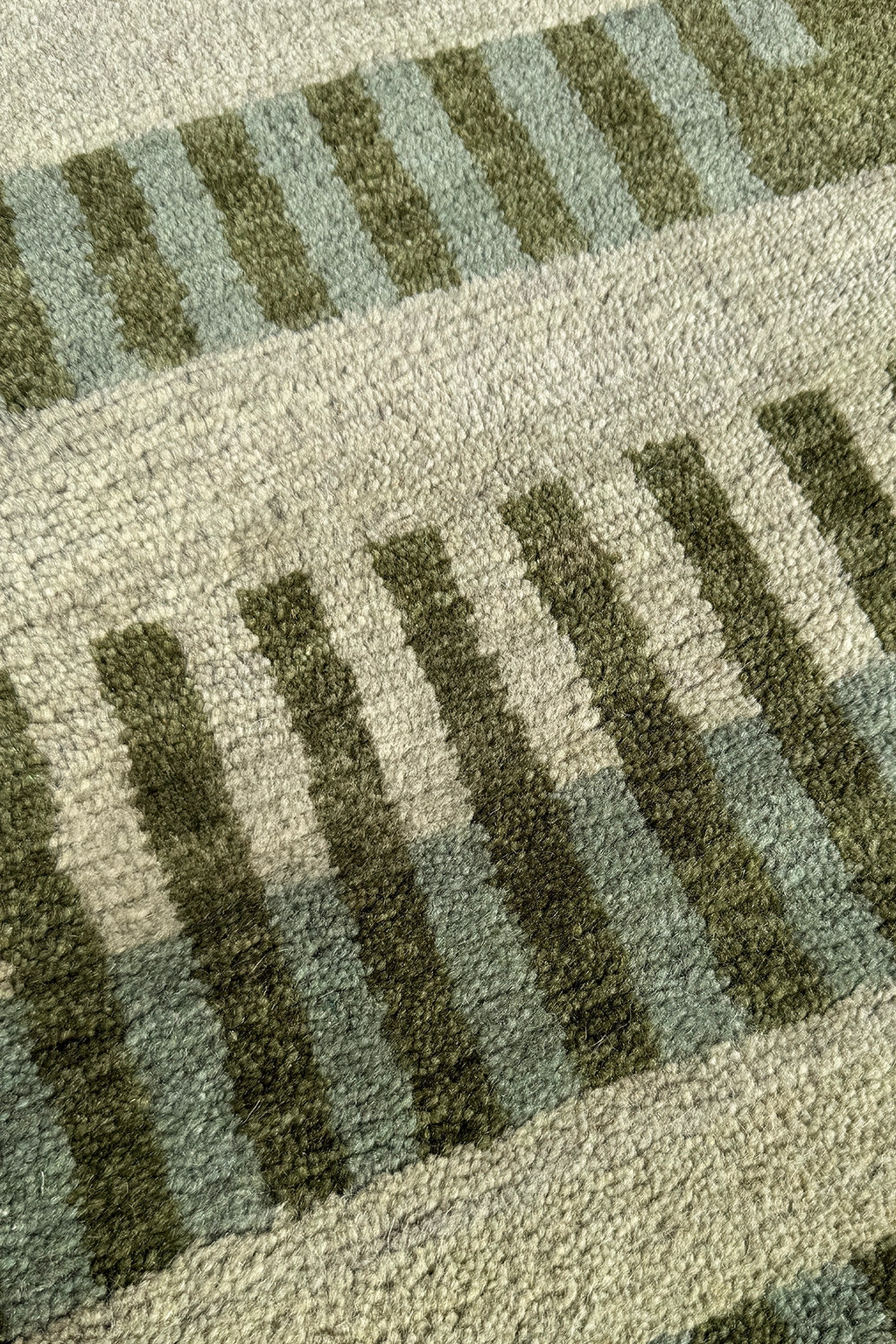 wool pile of a light green square rug