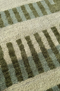 wool pile of a light green square rug