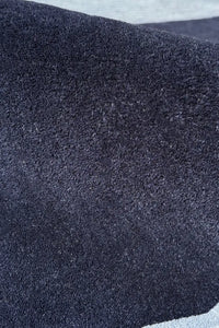 Navy blue hand-tufted wool rug with rich texture for modern or moody interiors