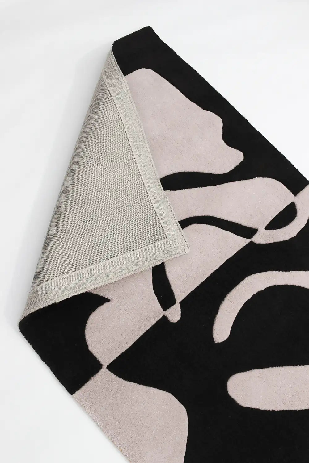 Black and white hand-tufted wool rug with thick sculptural organic lines