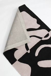 Black and white hand-tufted wool rug with thick sculptural organic lines