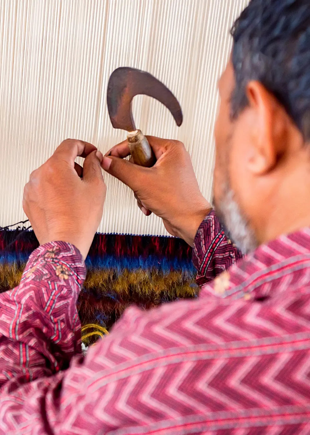 artisan weaving a rug with a traditional loom, focusing on the intricate craft.