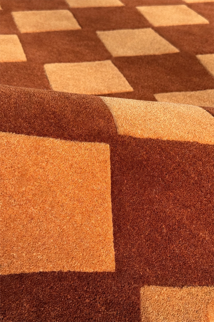 wool texture of a gold brown square tufted rug