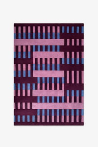 6x9 rug with a geometric pattern of pink and blue bars on a dark purple background