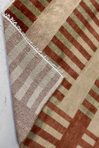striped multicolor hand knotted wool rug with geometric bands of burnt orange, tan, and olive