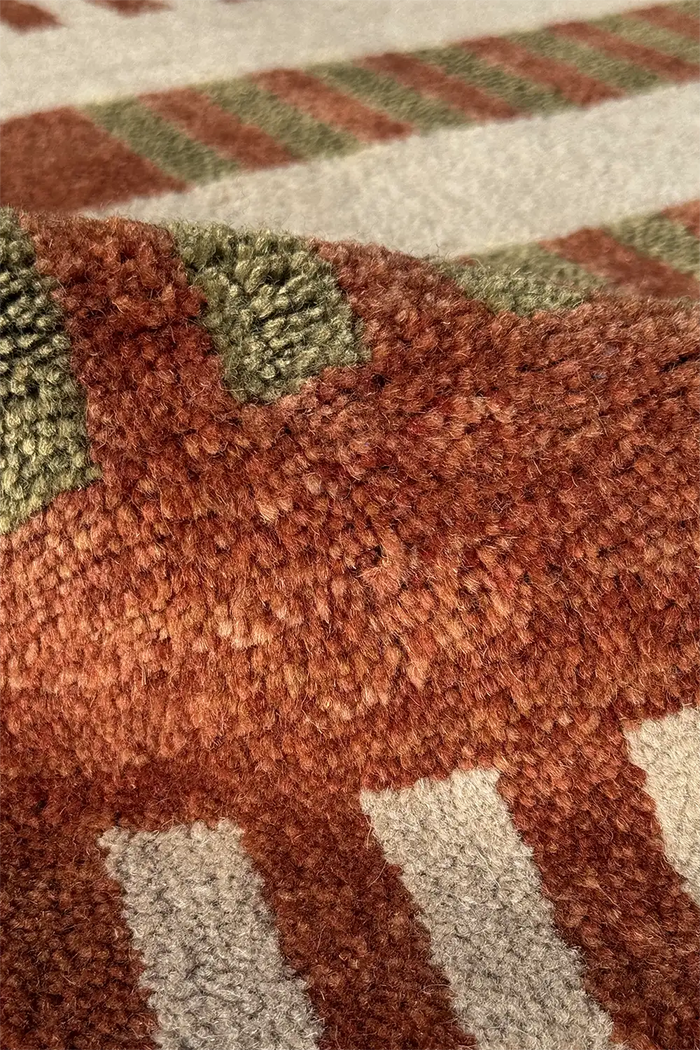 Close-up of a textured runner rug with geometric multicolor pattern in earthy tones.