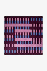 square rug with a geometric pattern of pink and blue bars on a purple background