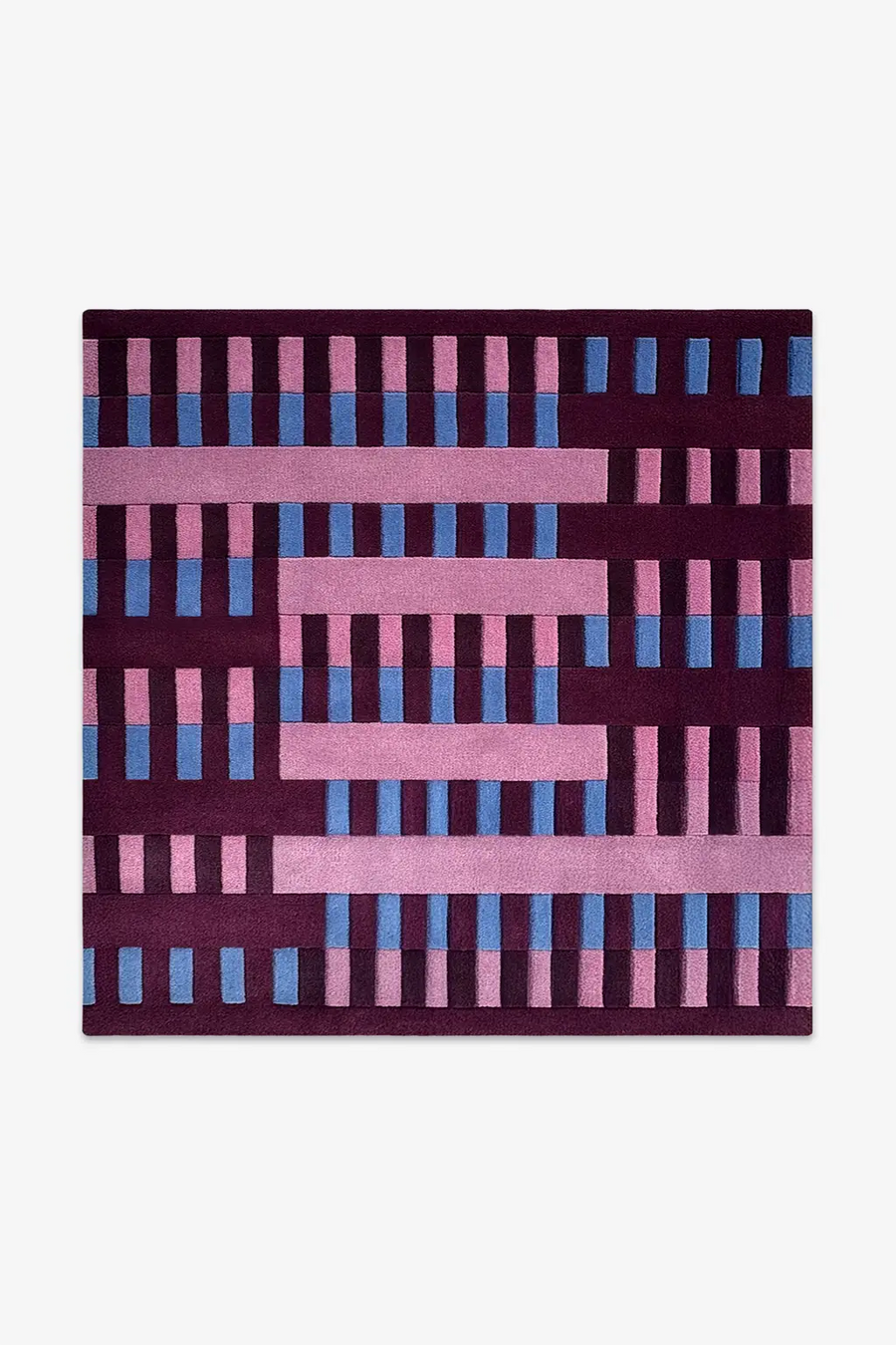 square rug with a geometric pattern of pink and blue bars on a purple background