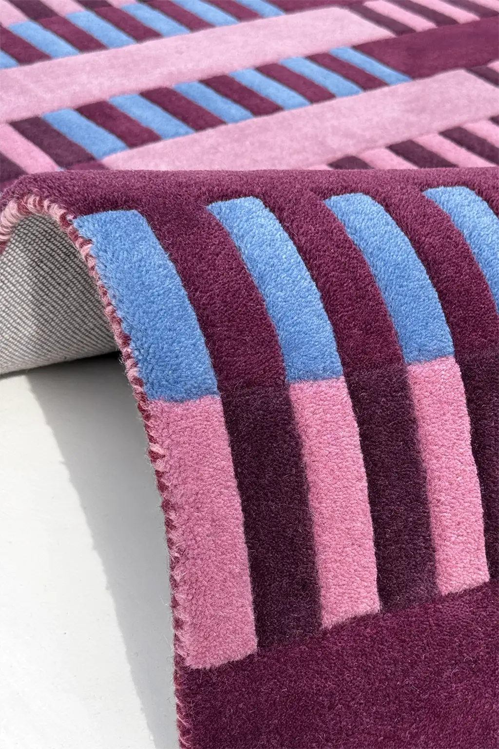 Close-up of a textured purple and blue striped wool rug